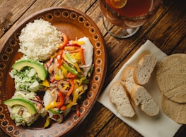 a plate of food on a table next to a glass of beer