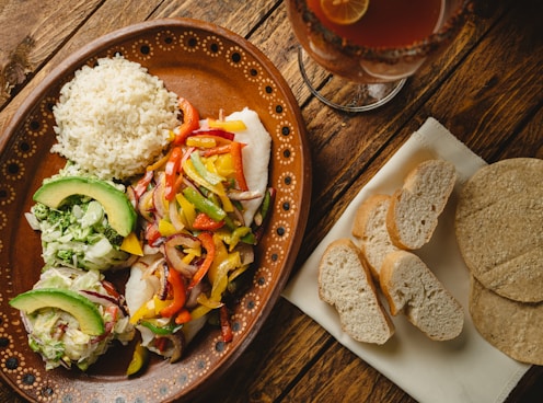 a plate of food on a table next to a glass of beer