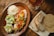 A festive table set with traditional Venezuelan holiday dishes, including colorful hallacas and a vibrant salad.