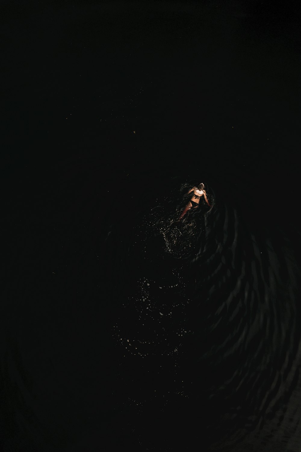 a person floating in the water at night