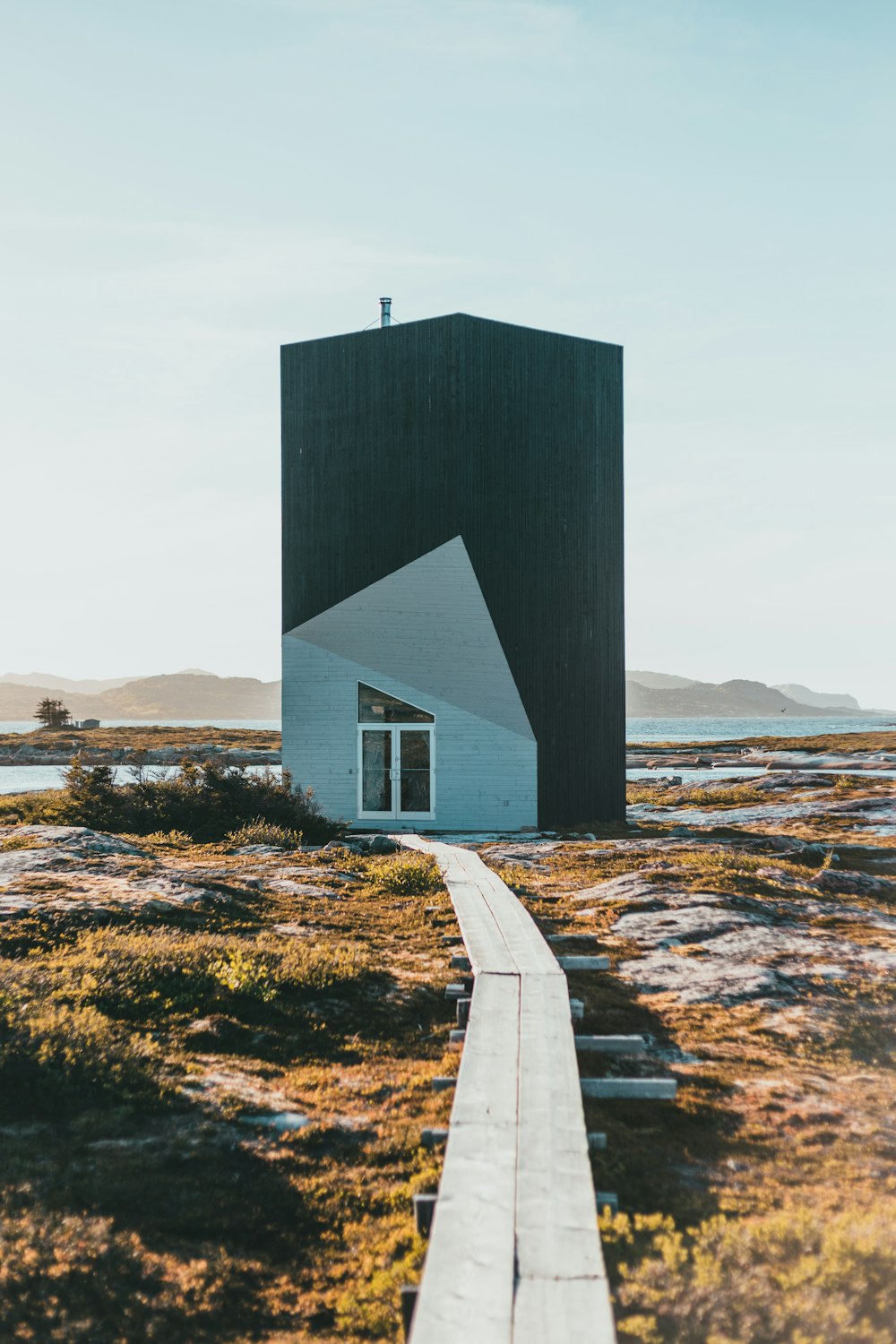 a black and white building with a walkway leading to it