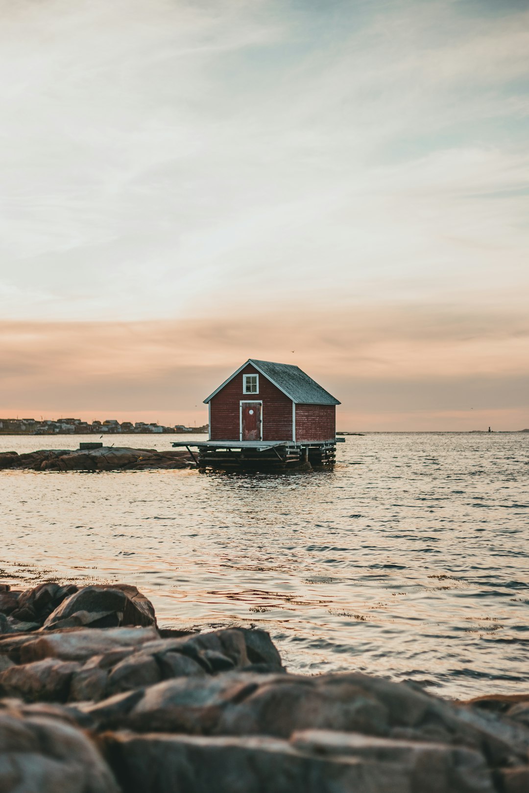 red and white wooden house on body of water during daytime