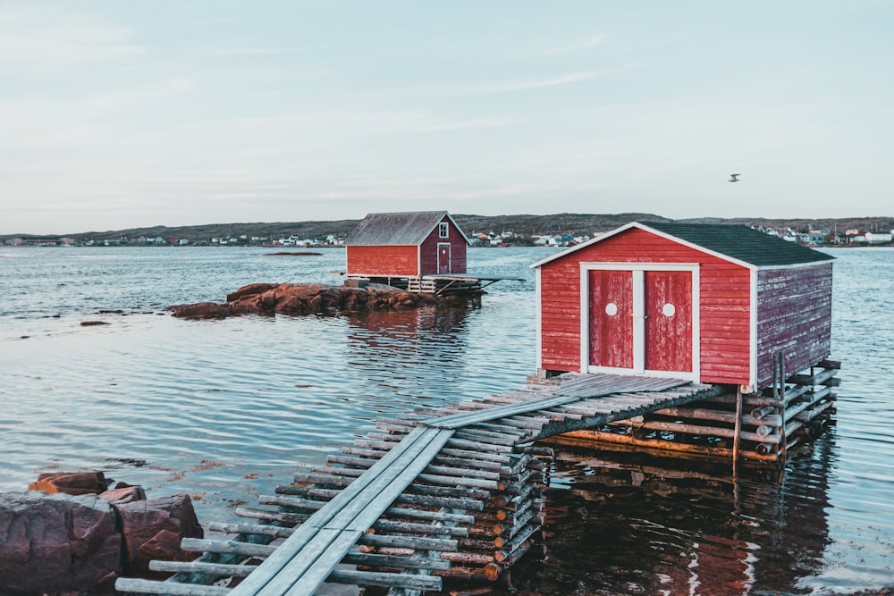 a red boathouse sitting on top of a body of water