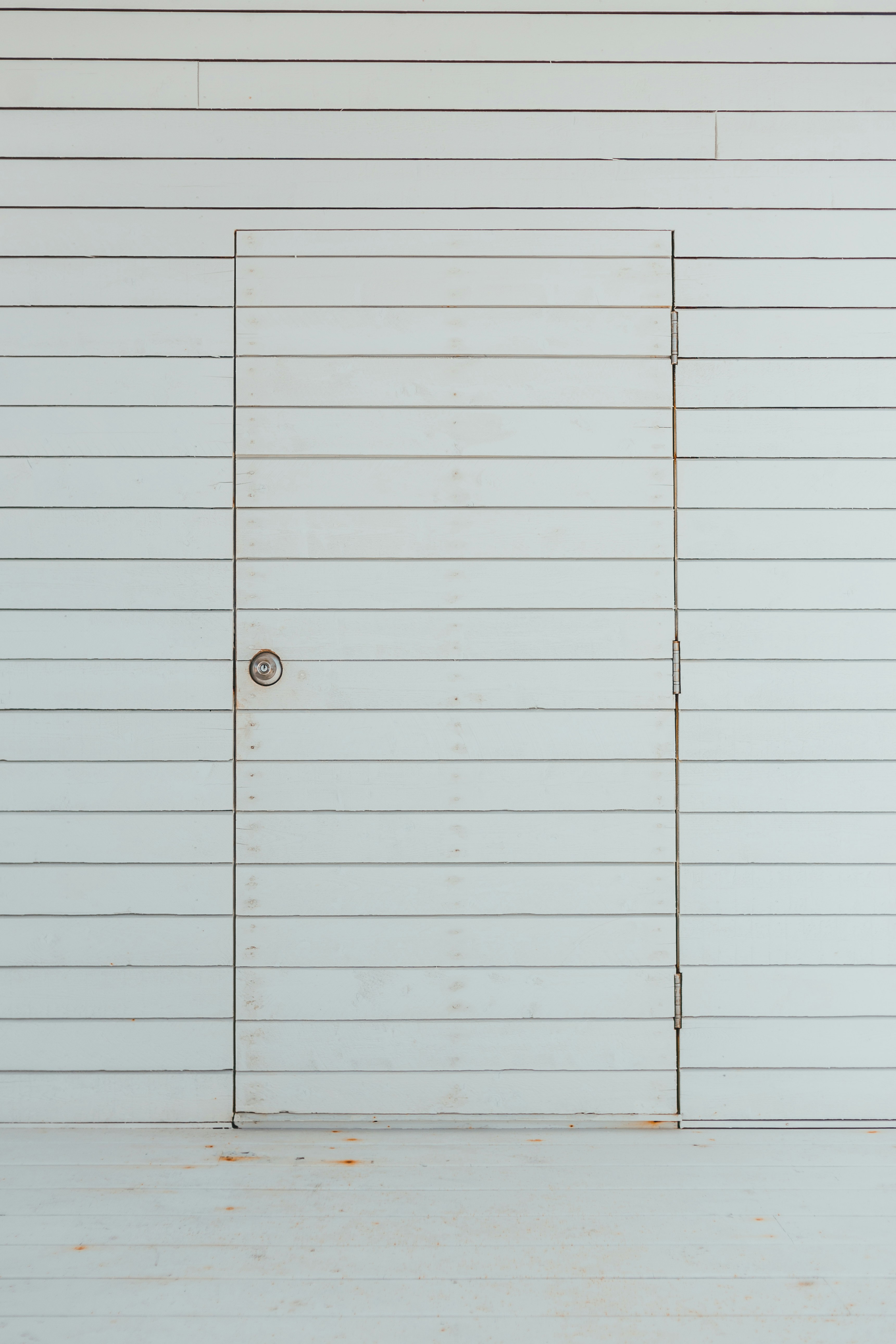 a white door with a metal handle on a white wall