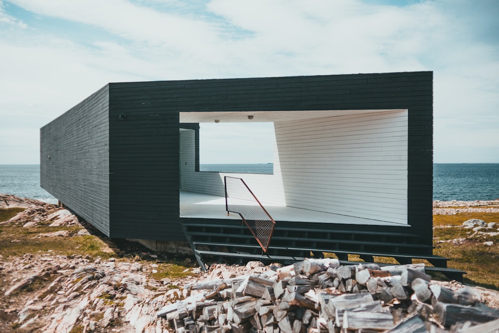 a black and white house sitting on top of a rocky hillside