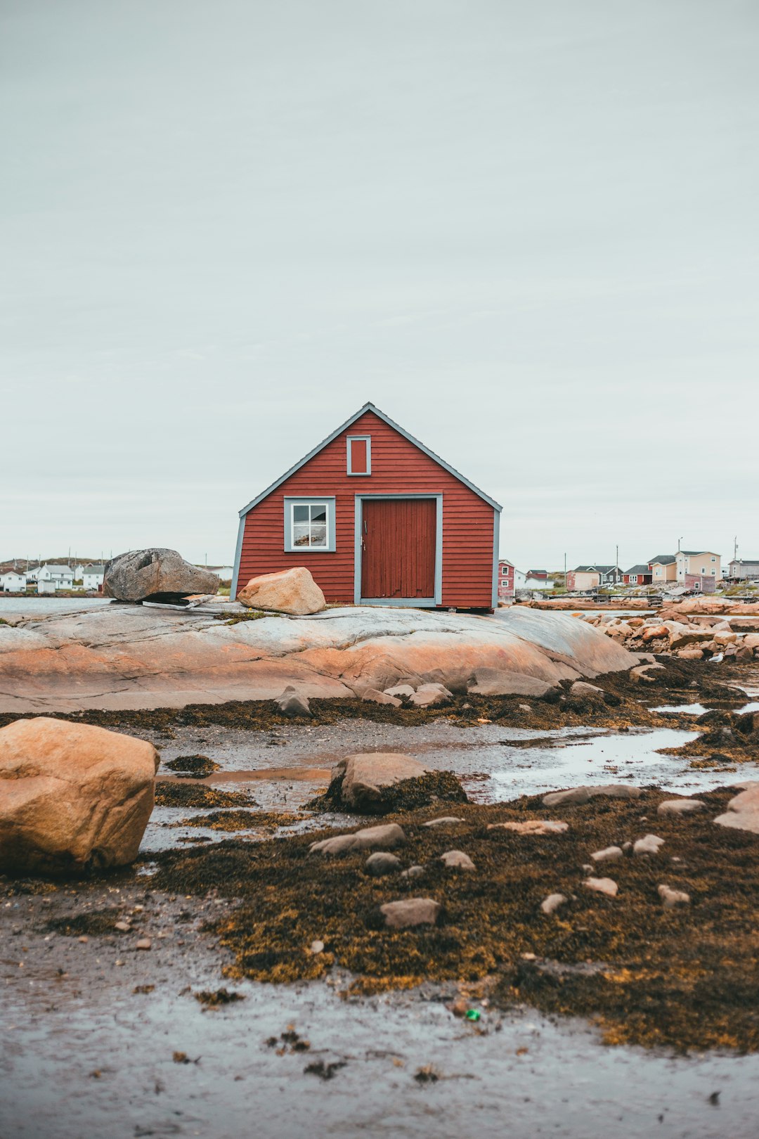 red and white wooden house near body of water during daytime