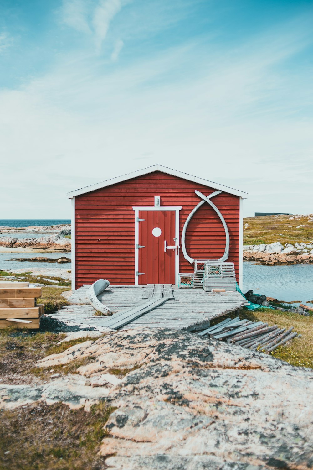 red and white wooden house near body of water during daytime