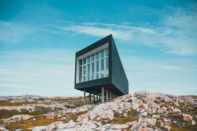 A sleek, modern modular building being assembled on a rocky mining site under clear skies.
