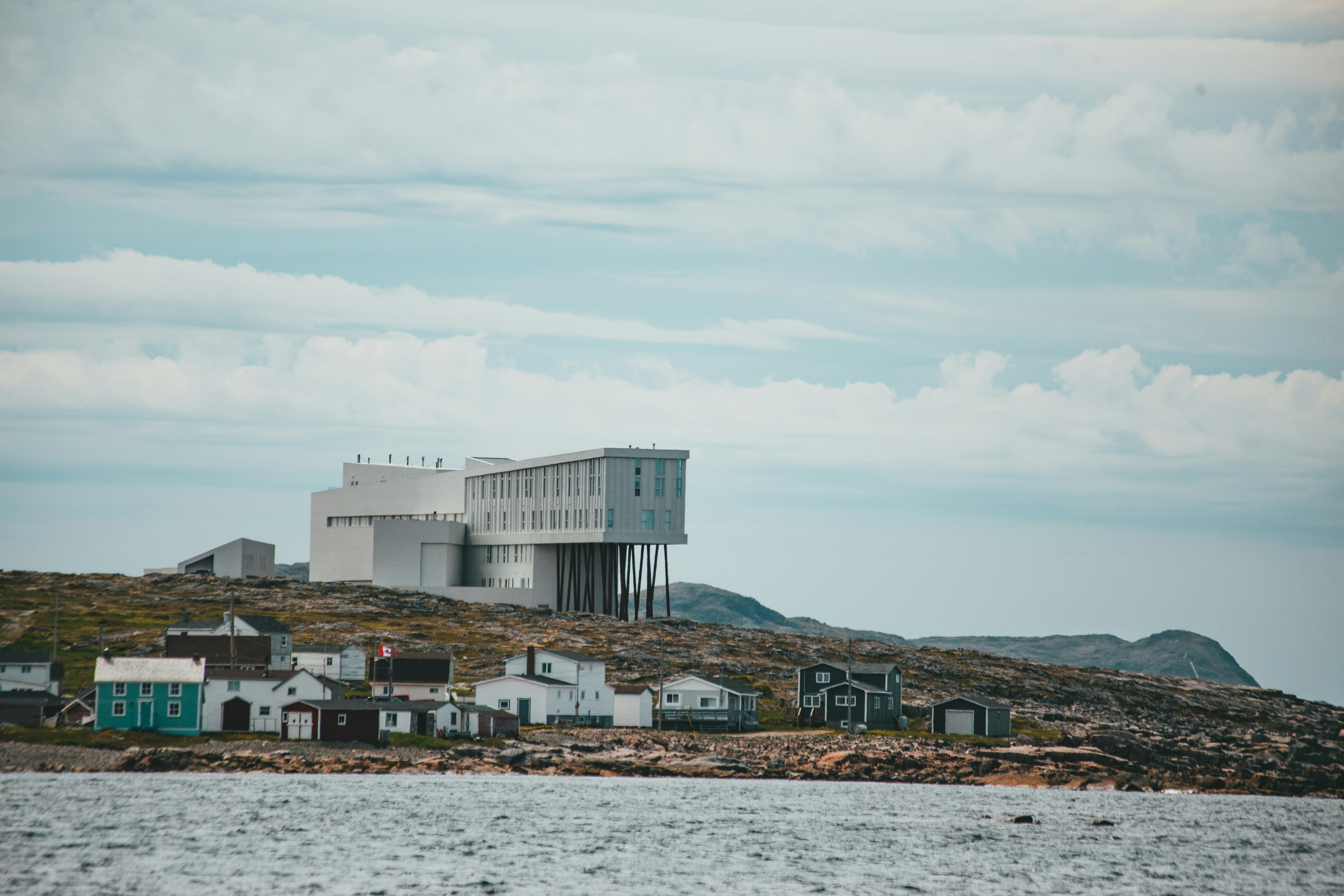 White and gray house on brown field under white clouds during daytime ...