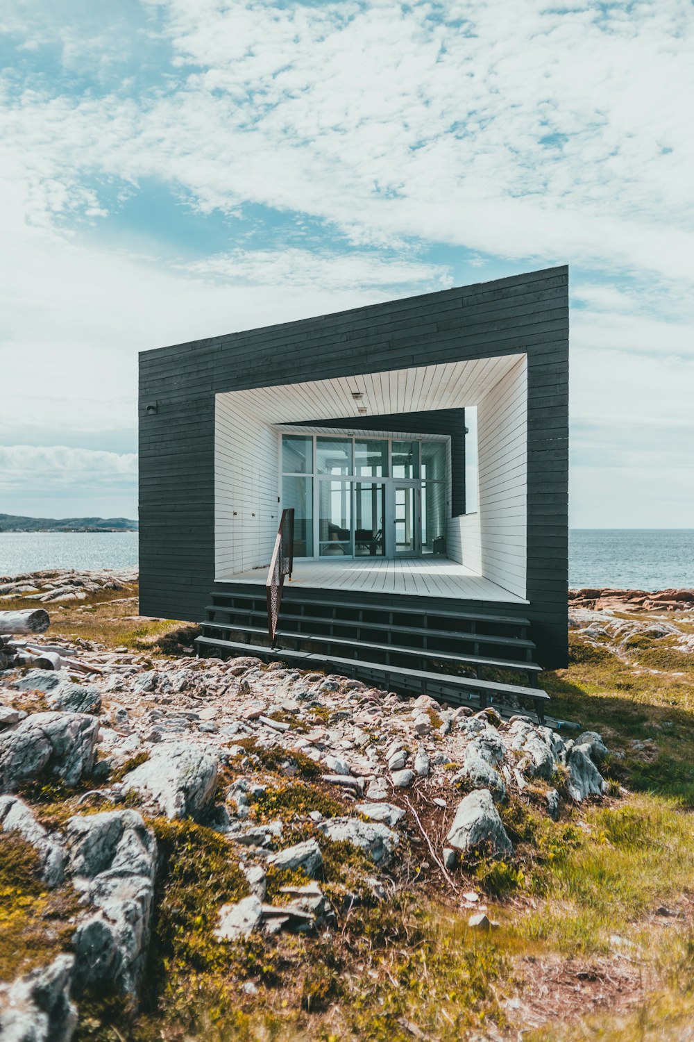 white and gray wooden house near body of water during daytime