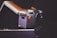 A close-up shot of a vintage instant camera in silver with orange accents. The camera has a distinct retro design with a noticeable viewfinder and button. It is partly folded, displaying its mechanical structure and giving a sense of nostalgia.