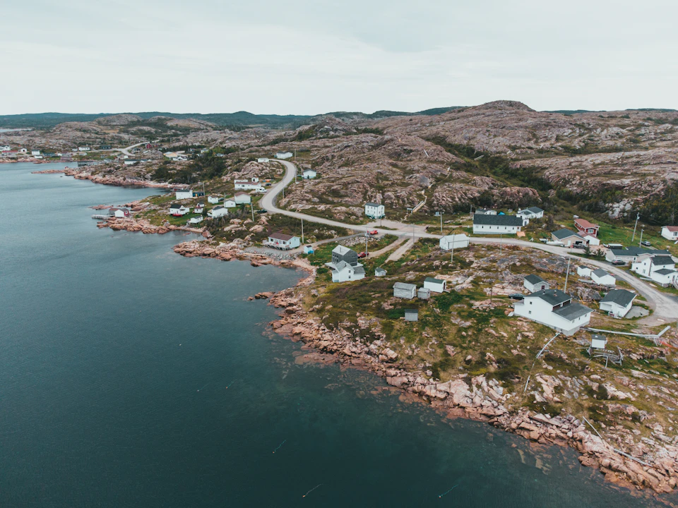 Small coastal town on a rocky cliff overlooking the ocean with white buildings