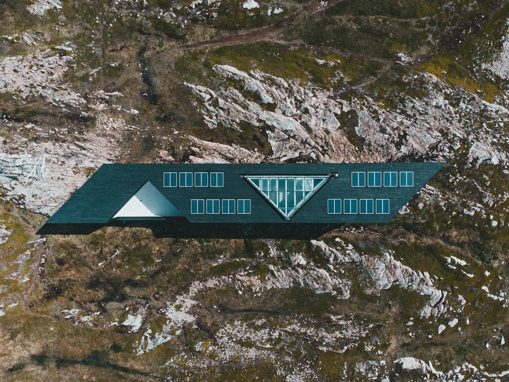 blue and white wooden house on rocky hill