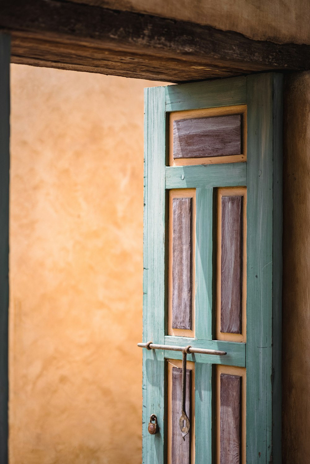 brown wooden window on yellow concrete wall