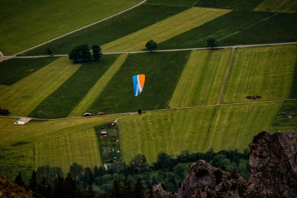 a colorful kite flying over a lush green field