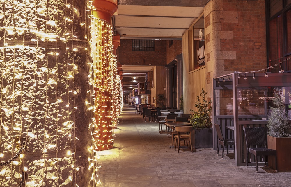 a long hallway with tables and chairs covered in lights