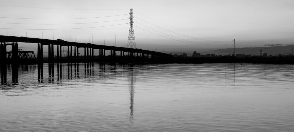 a black and white photo of a bridge over water