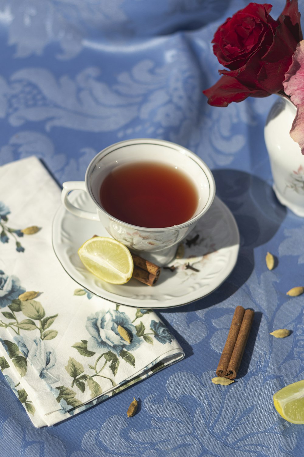 a cup of tea next to a plate with a slice of lemon on it