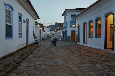 Cobblestone street lined with colorful colonial buildings bathed in golden light.