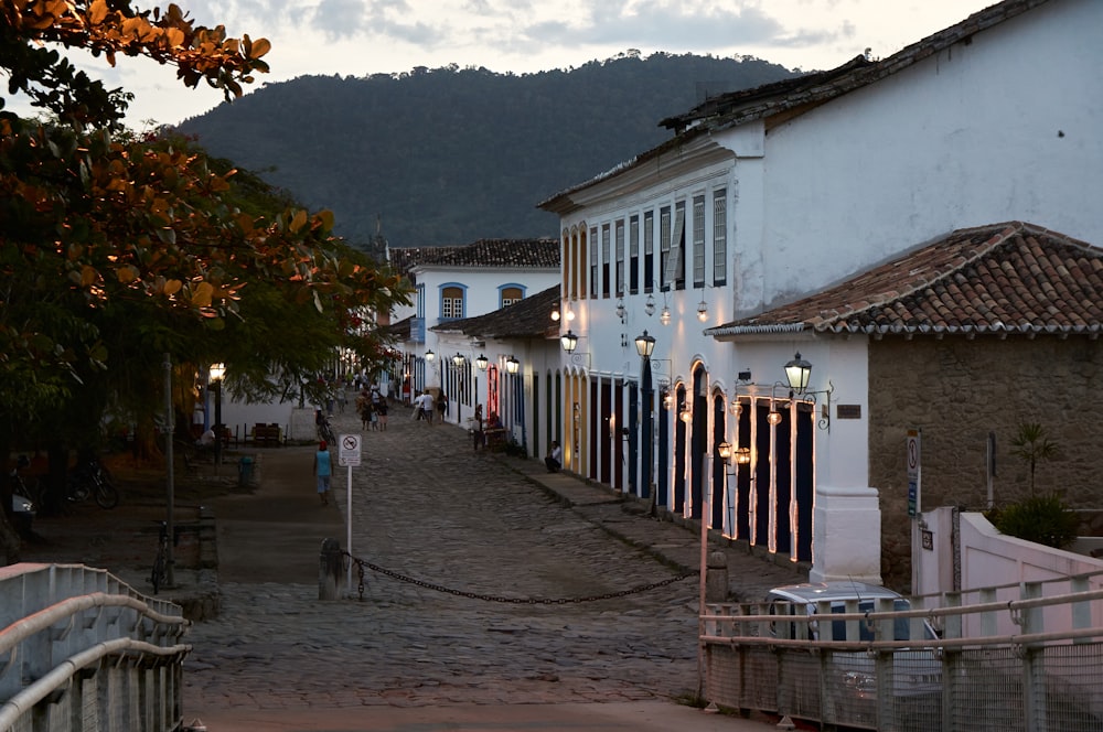 a cobblestone street lined with white buildings