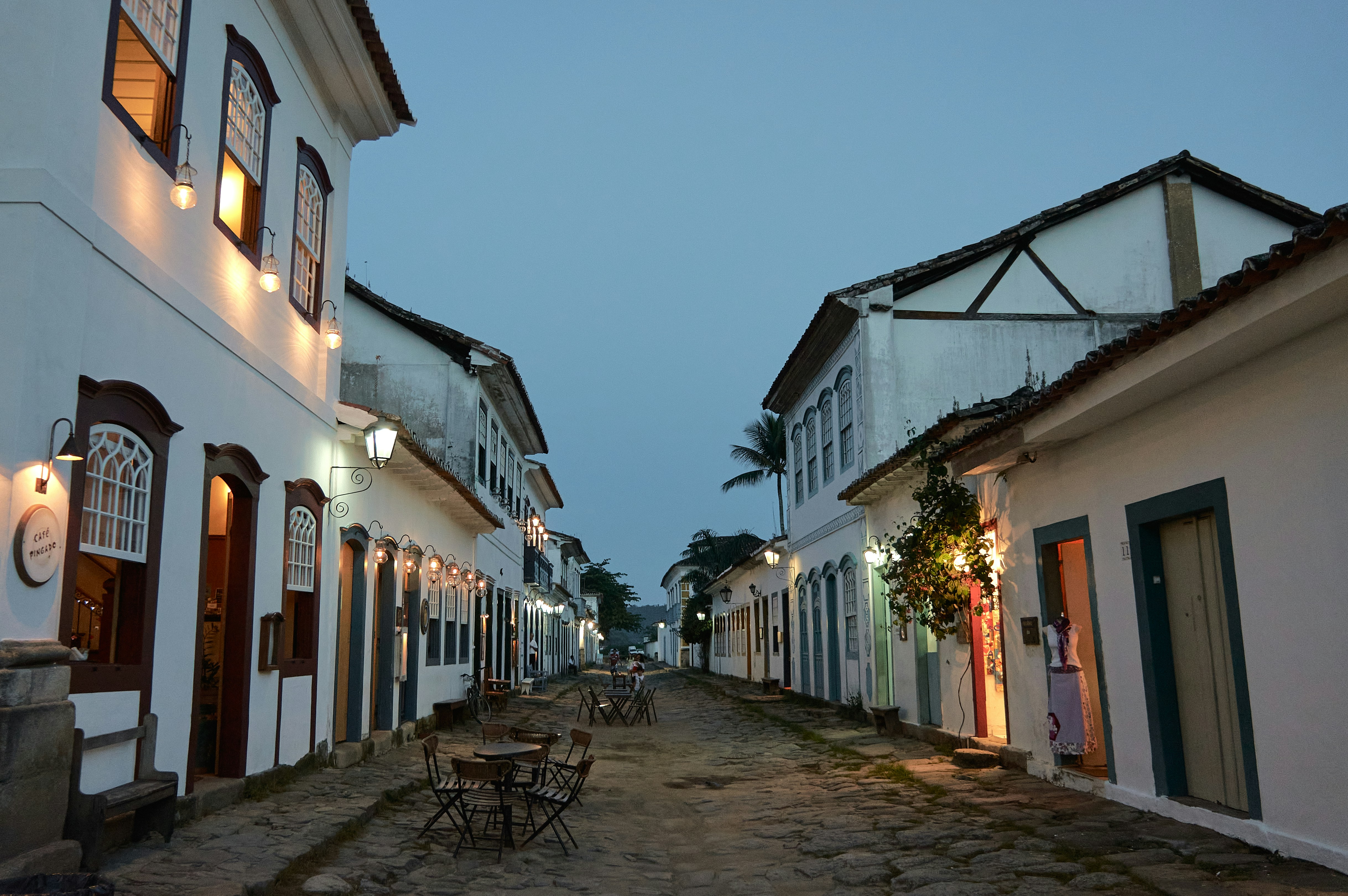 a cobblestone street lined with white buildings