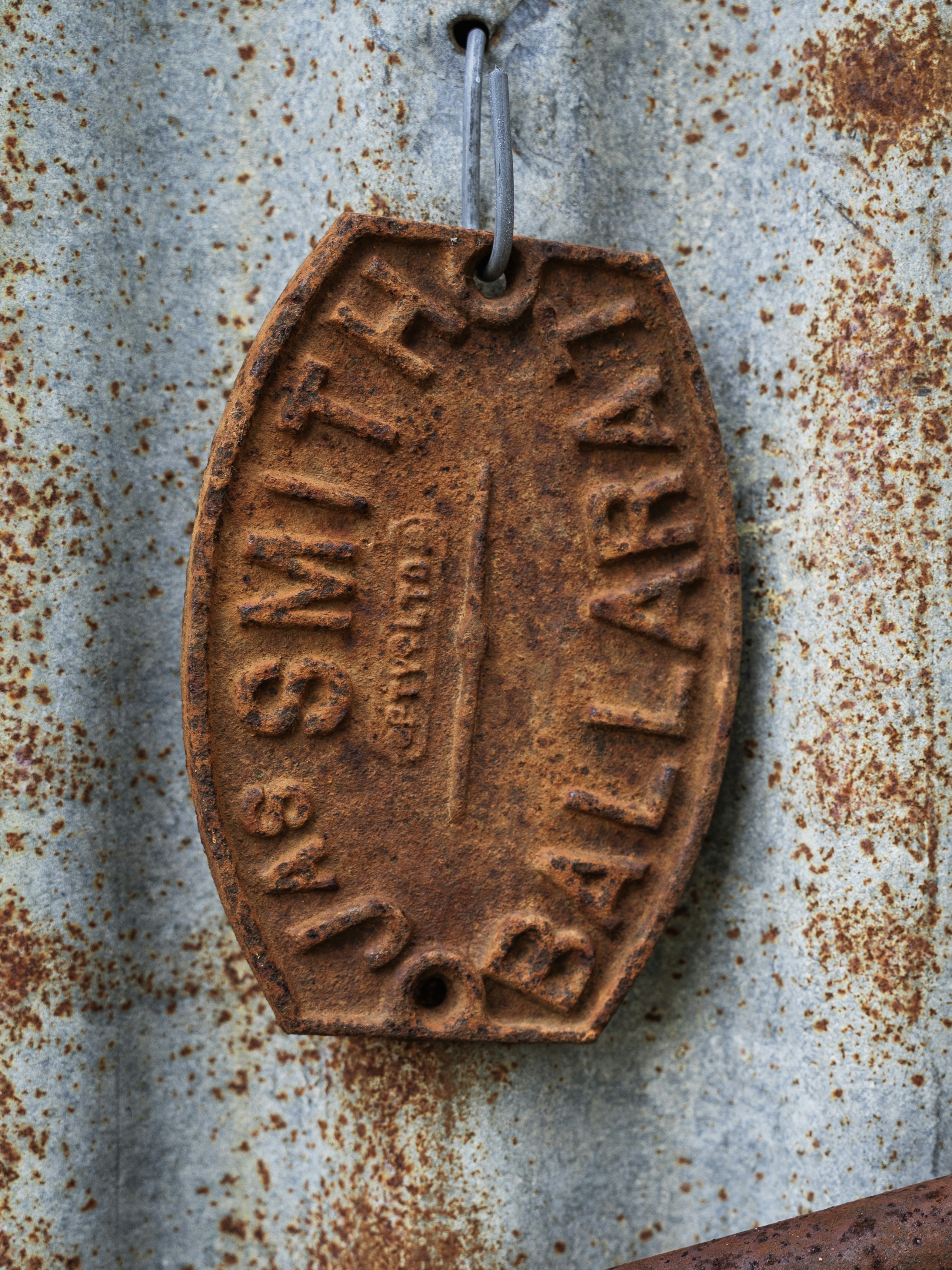a rusted metal sign hanging on a rusted metal wall