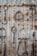 A variety of rusted horse tack, including stirrups and bits, hang on a corrugated metal wall. Each piece displays varying degrees of rust and wear, contrasting with the metallic background. The arrangement creates a rustic and vintage aesthetic.