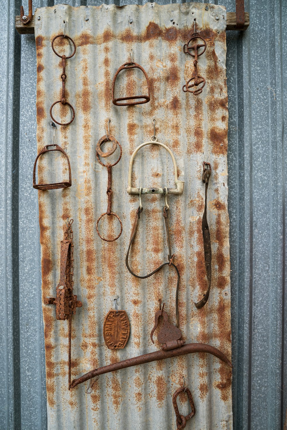a rusted metal wall with a bunch of rusty objects on it