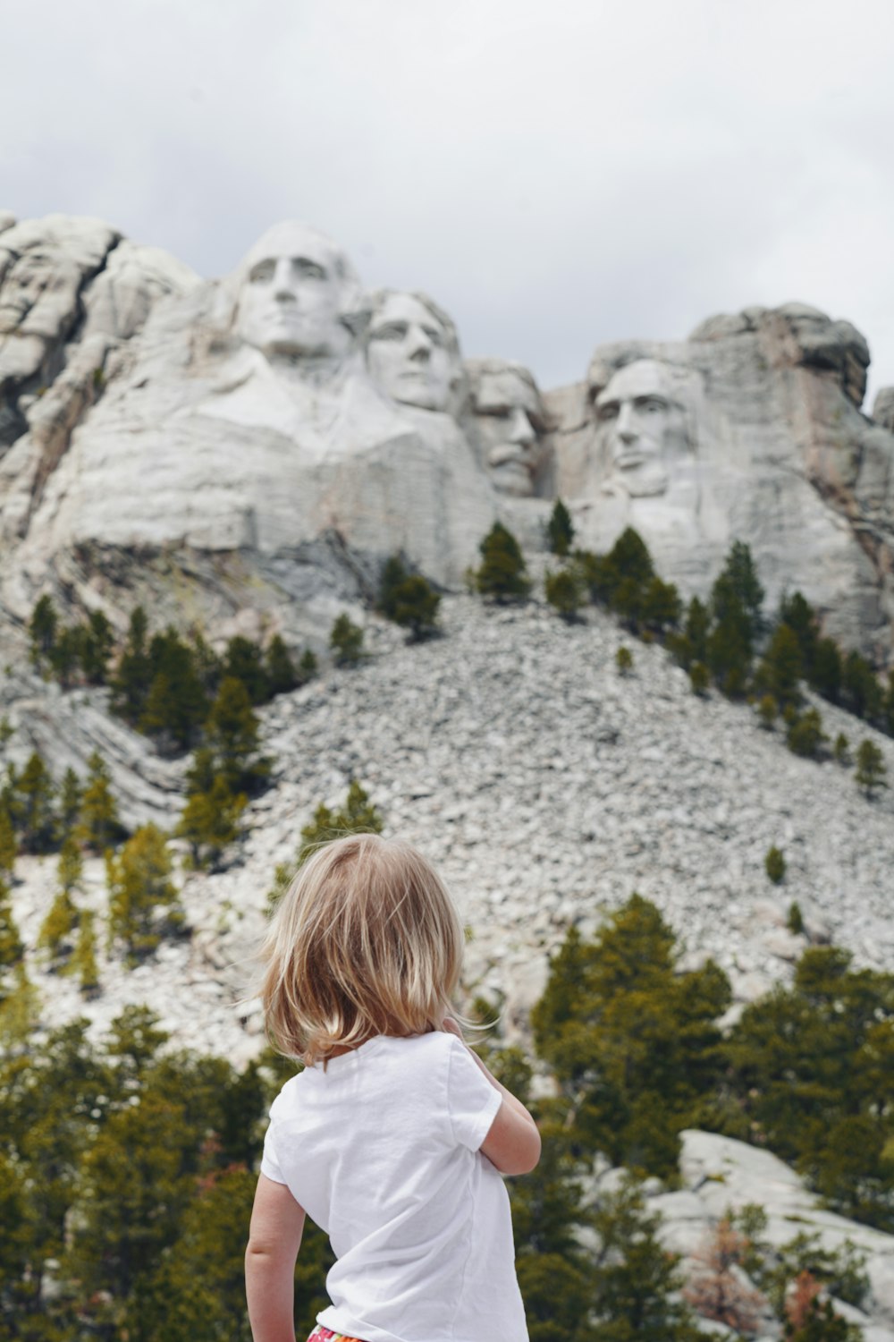 Una niña parada frente a una montaña