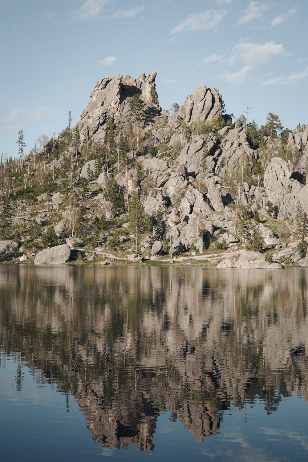 gray rock formation beside body of water during daytime