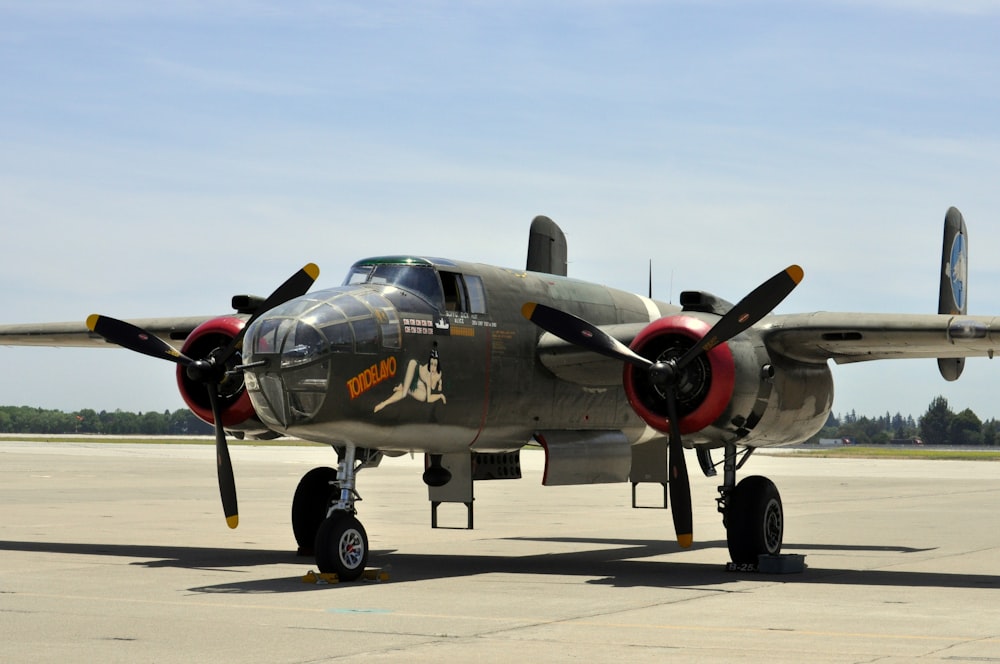 a propeller plane sitting on top of an airport tarmac