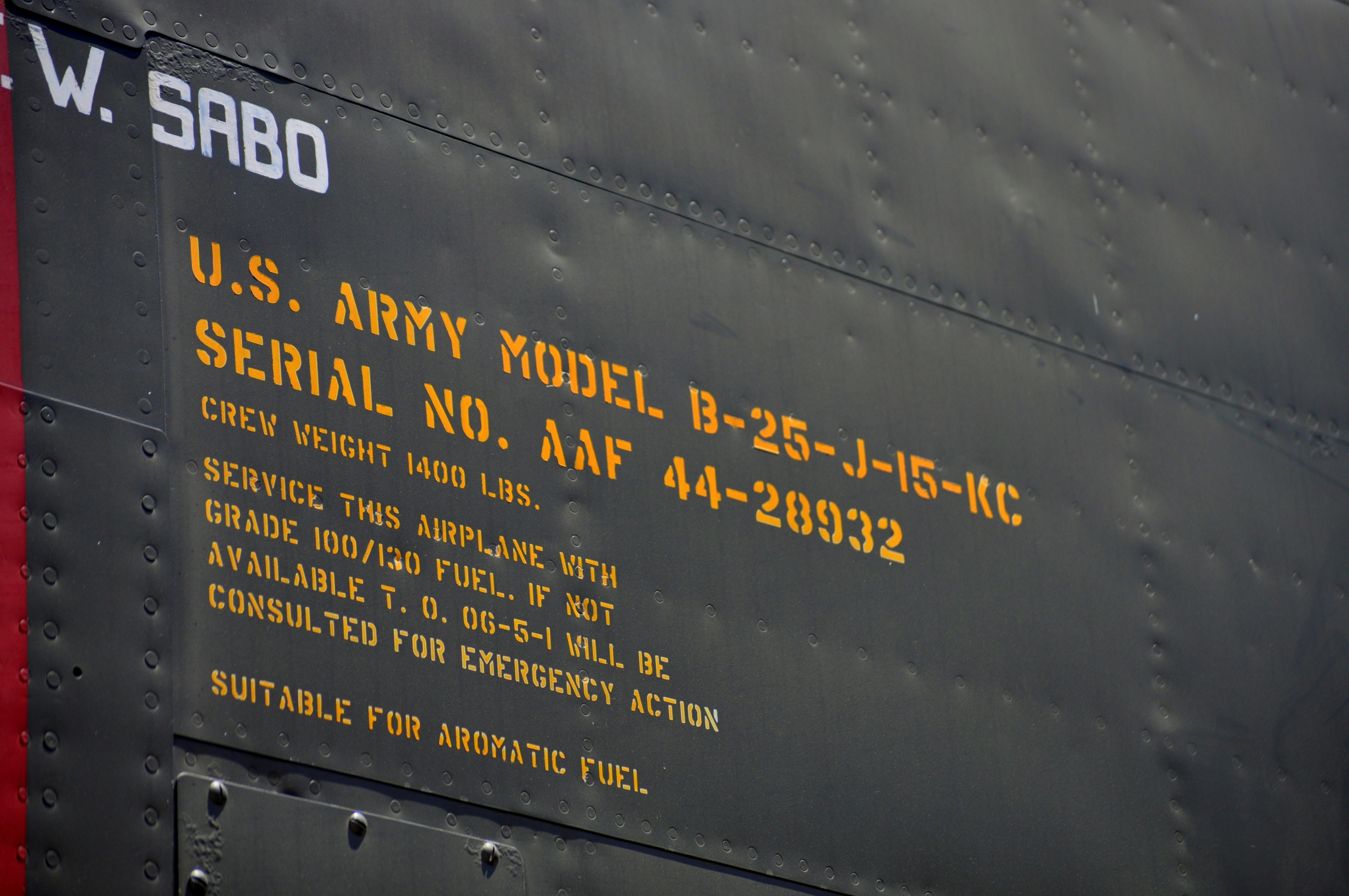 a close up of the side of a military aircraft, SPECIFICATIONS (B-25J)</p><p>Crew: 6 (Pilot, Co-Pilot, Bombardier/Navigator, Flight Engineer, Radio Operator and Tail Gunner)</p><p>Wingspan: 68 feet</p><p>Length: 53 feet</p><p>Maximum Speed: 272 miles per hour</p><p>Cruising Speed: 230 miles per hour</p><p>Maximum Range: 1,350 miles</p><p>Engines: Two Wright R-2600-92s (1,700 hp each)</p><p>Maximum Bomb Load: 3,200 pounds</p><p>Armament: Twelve to eighteen .50 caliber machine guns