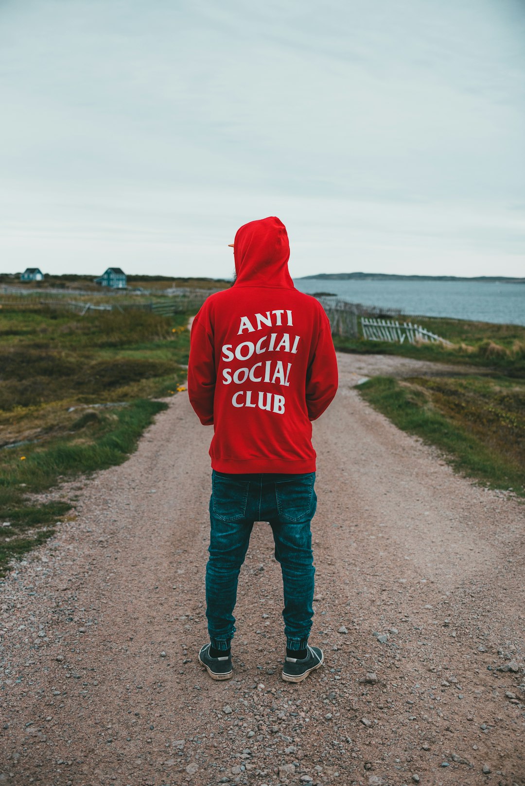 man in gray hoodie standing on road during daytime