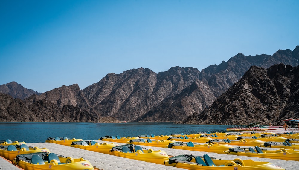 a row of yellow boats sitting on top of a lake