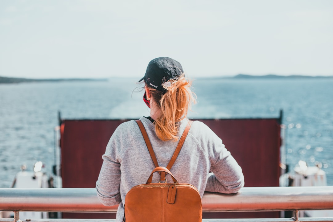 woman in white and pink long sleeve shirt sitting on red bench