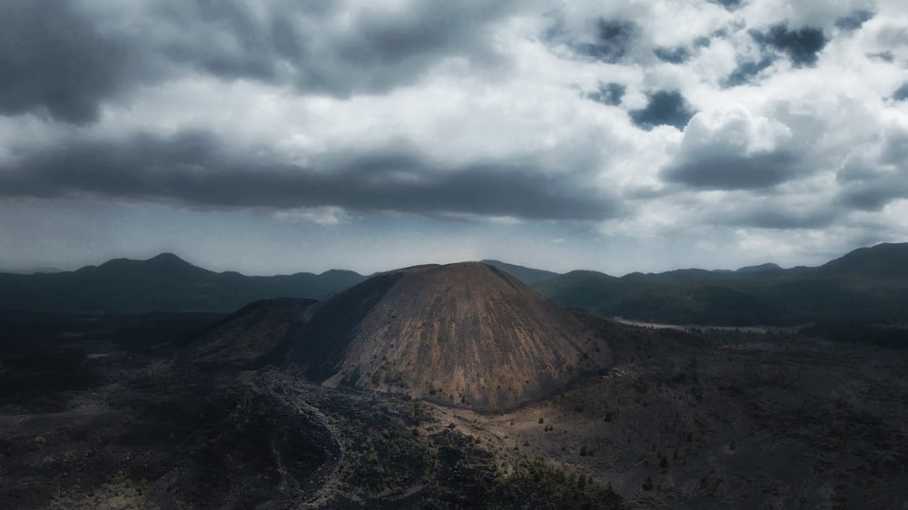 昼間の白い雲の下の茶色の山