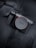 A Sony camera body resting on a dark fabric surface, featuring the brand's logo prominently on the lens cap. The camera is sleek with a modern design and a dark color palette, featuring metallic and black elements.