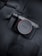 A Sony camera body resting on a dark fabric surface, featuring the brand's logo prominently on the lens cap. The camera is sleek with a modern design and a dark color palette, featuring metallic and black elements.