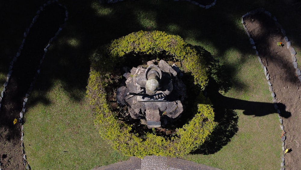 a bird's eye view of a statue in the middle of a garden