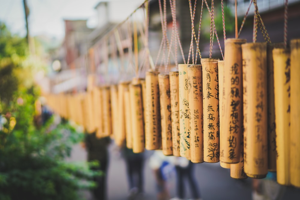 a row of yellow chinese prayer wheels hanging from a line