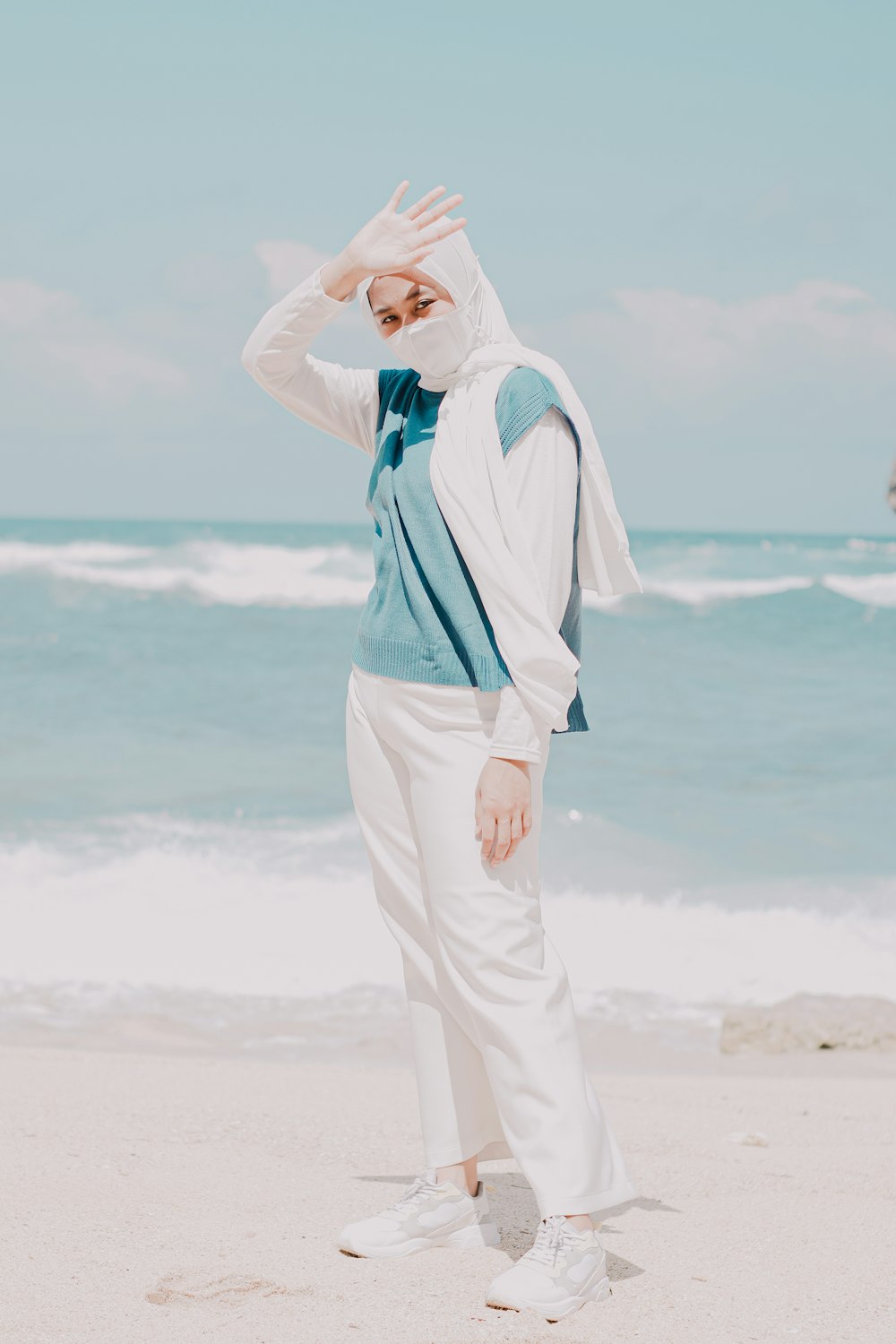 a woman standing on top of a sandy beach