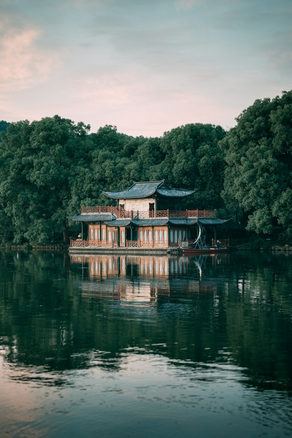 a boat floating on top of a lake next to a forest