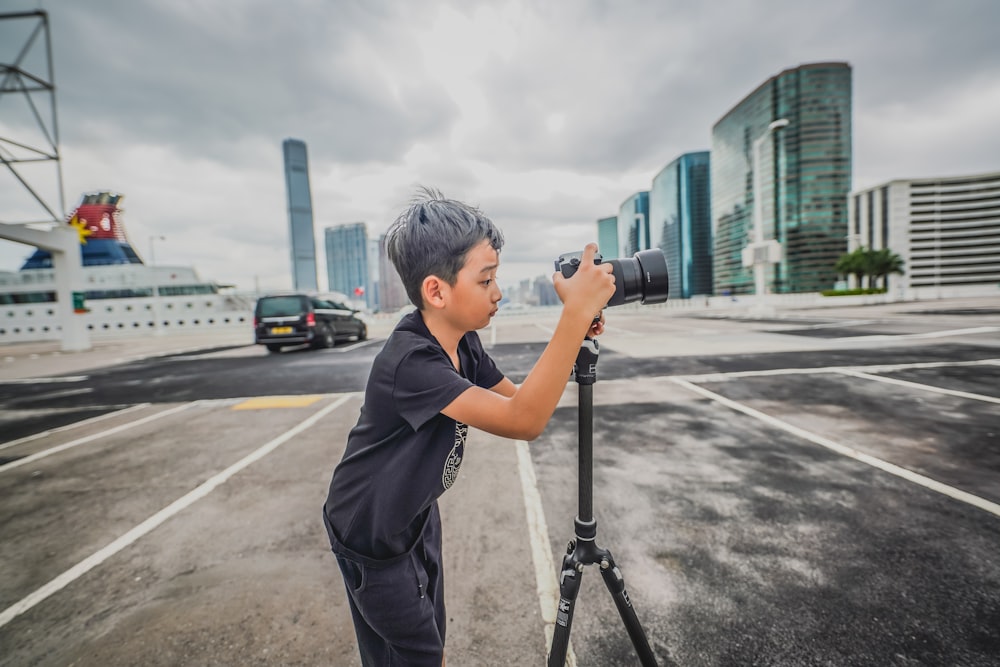 a young boy taking a picture with a camera