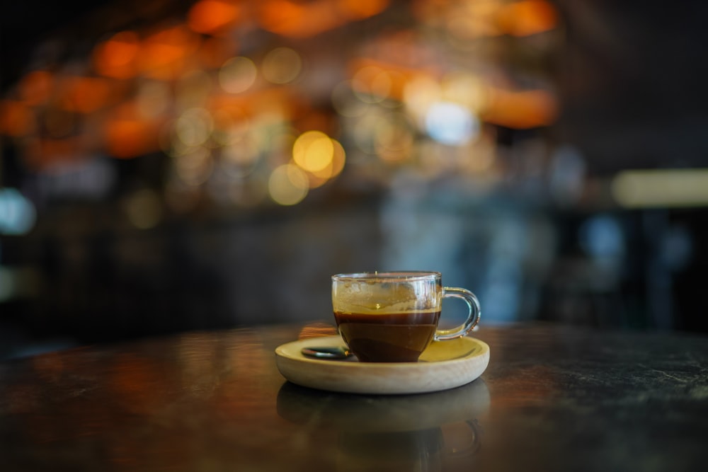 a cup of coffee sitting on top of a wooden table