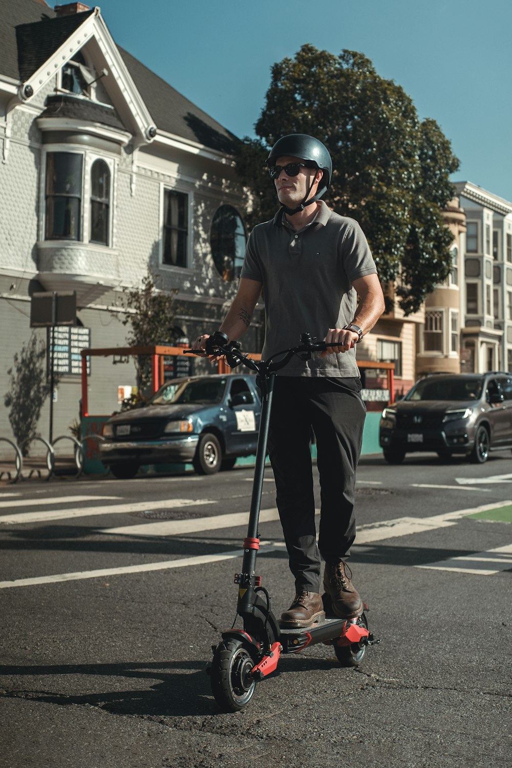 黒いTシャツと黒いヘルメットをかぶった男が昼間、道路を自転車で走っている