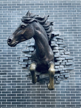 a statue of a horse on a brick wall