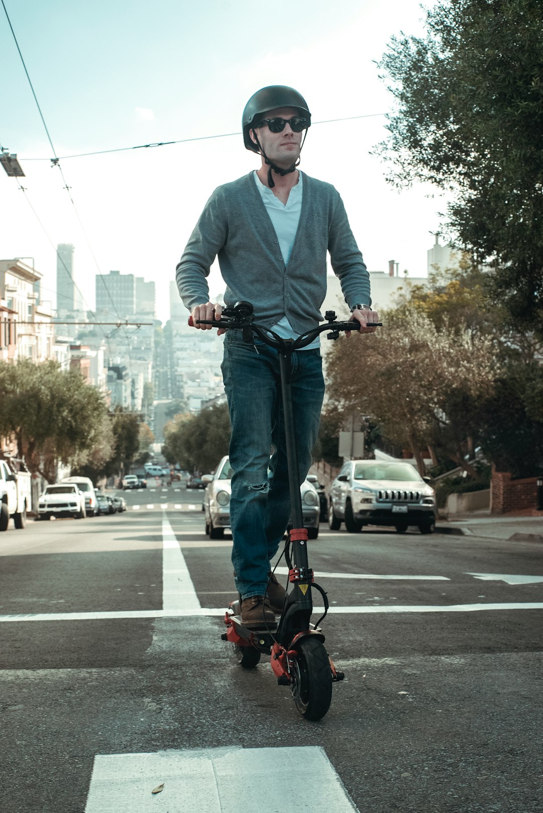 man in white dress shirt and blue denim jeans riding on black and red bicycle during
