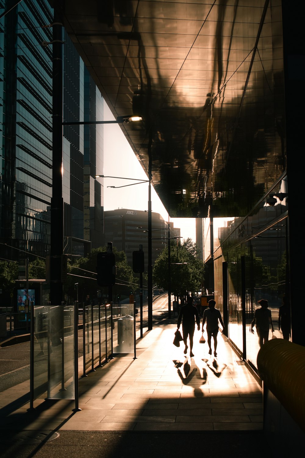 a group of people walking down a street next to tall buildings