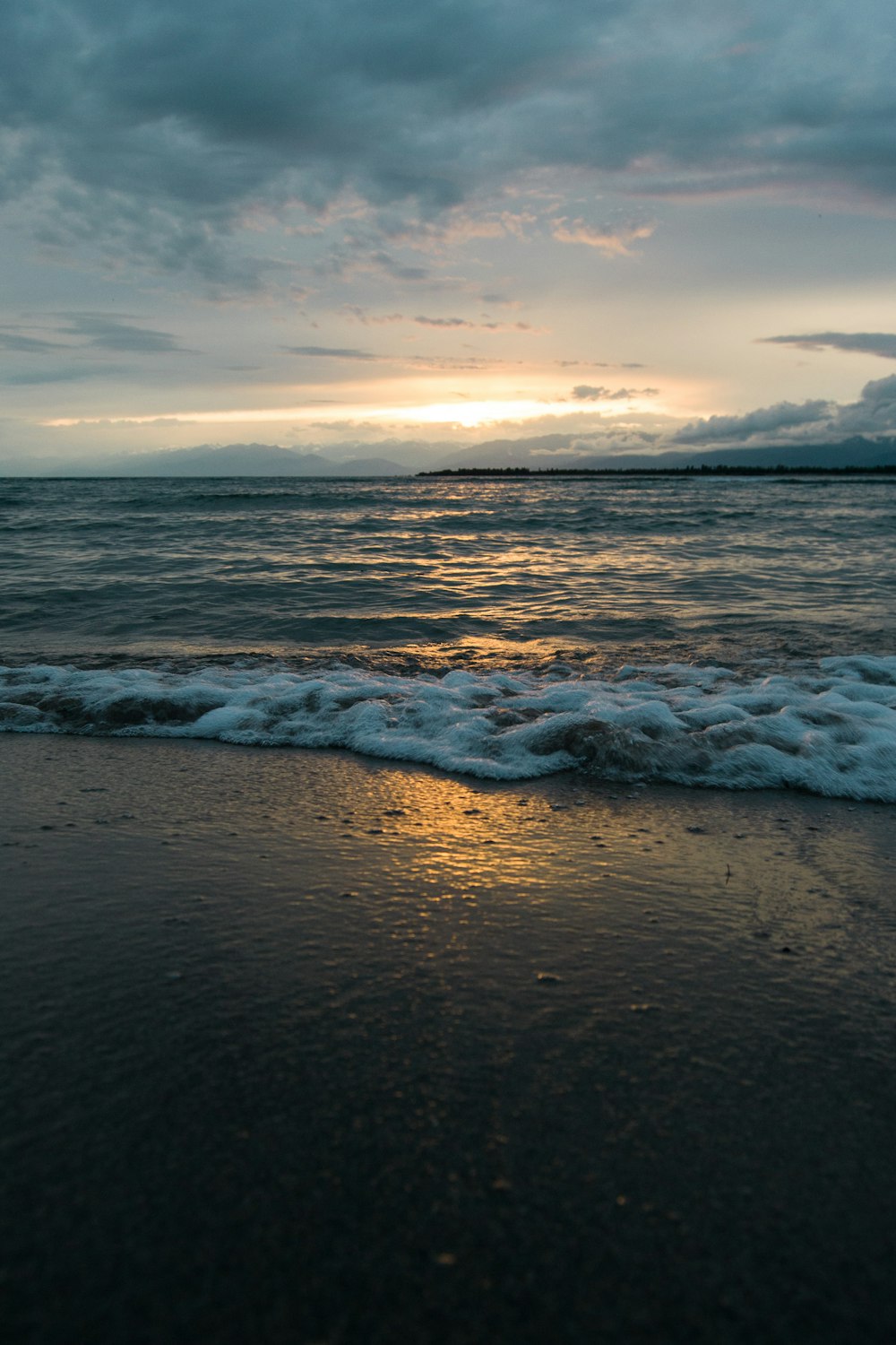 ocean waves crashing on shore during daytime