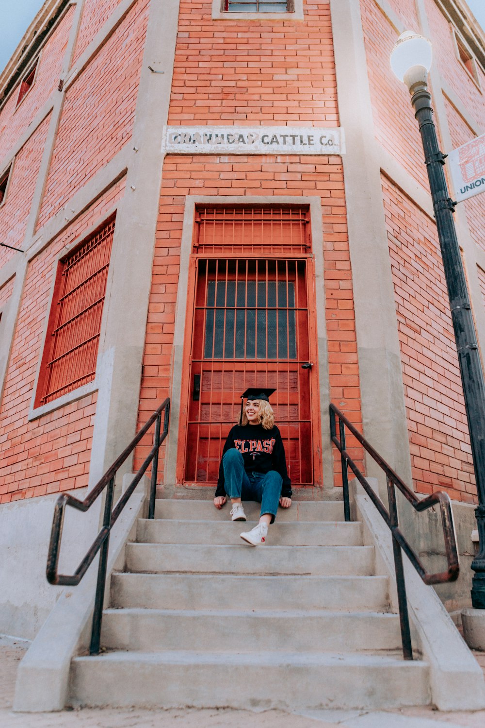 woman in blue jacket sitting on stairs